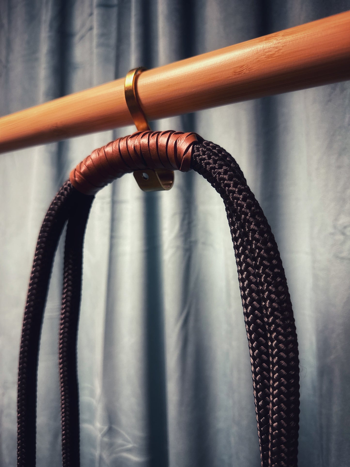 Onyx neckrope adjustable black nylon and cognac leather hanging on wooden hook