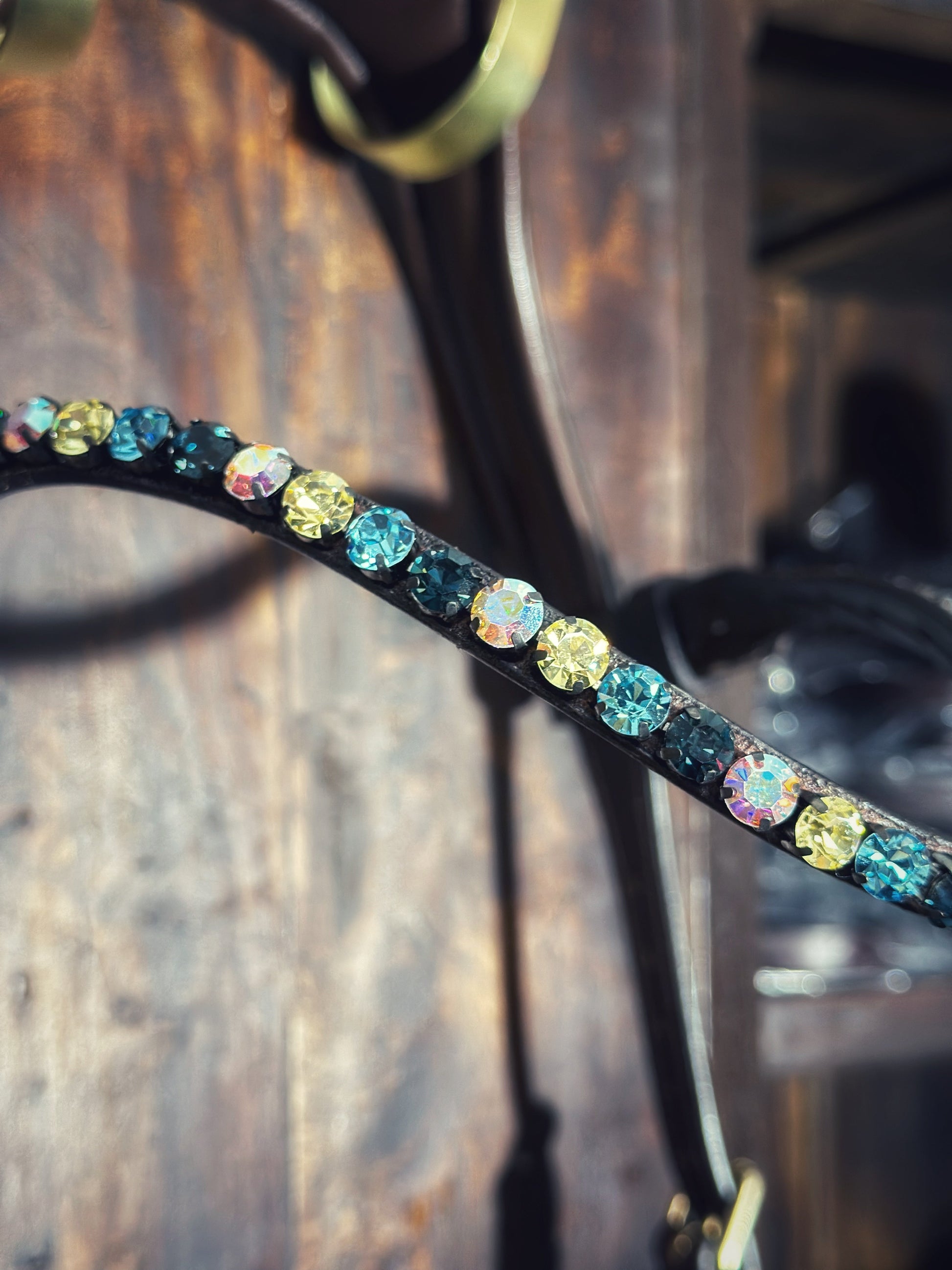 Close-up of a blue mint browband adorned with vibrant 8mm colored stones and a quick-release clasp for equestrian gear.