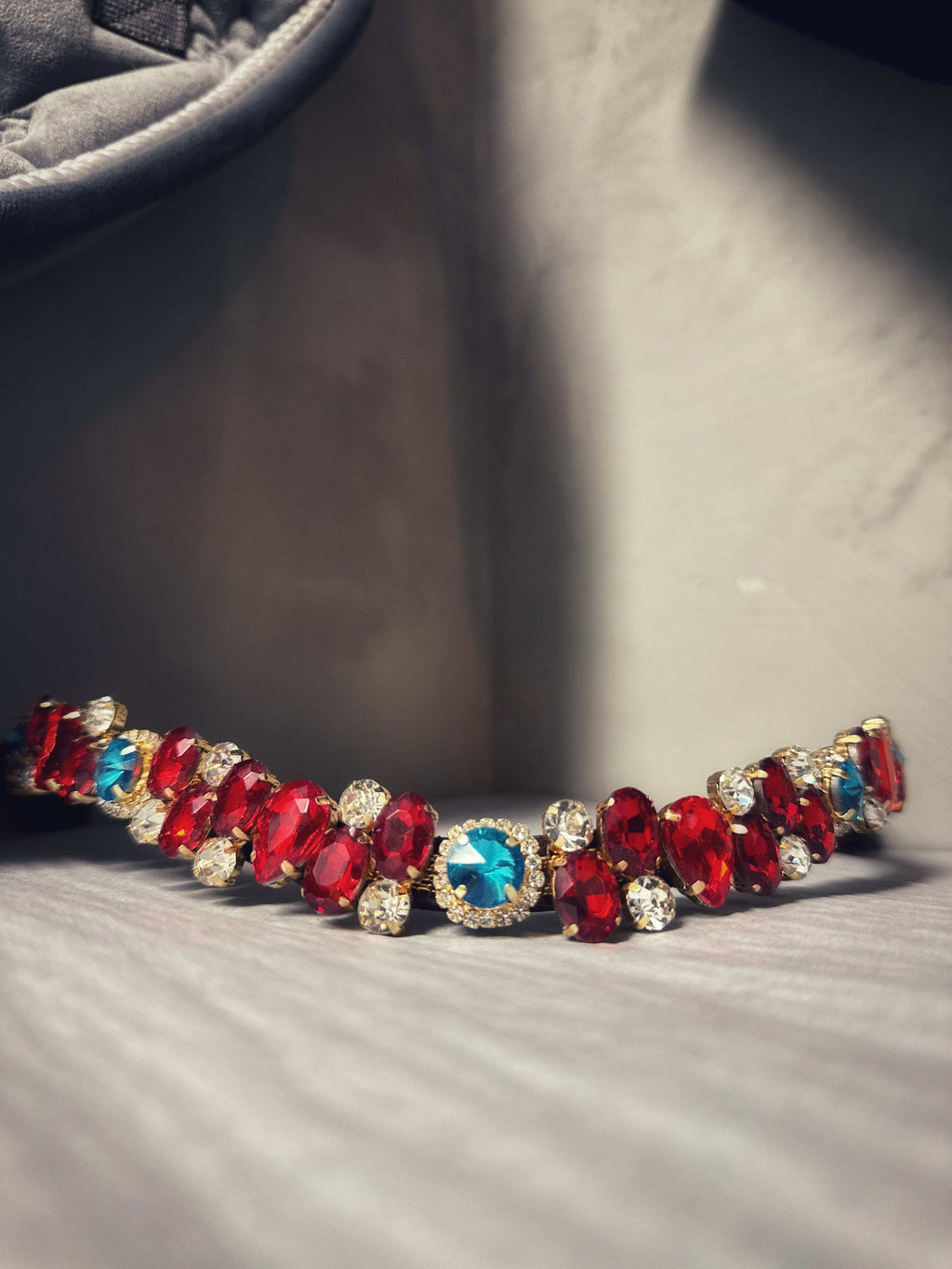Sample nr.1 brown full jewelry piece with red and blue gemstones on a gray surface