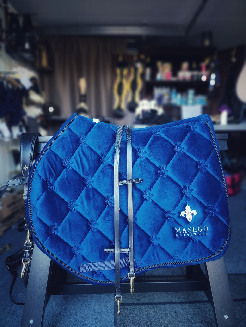 Royal blue velvet jumping saddle pad with golden Masego logo and quilted design