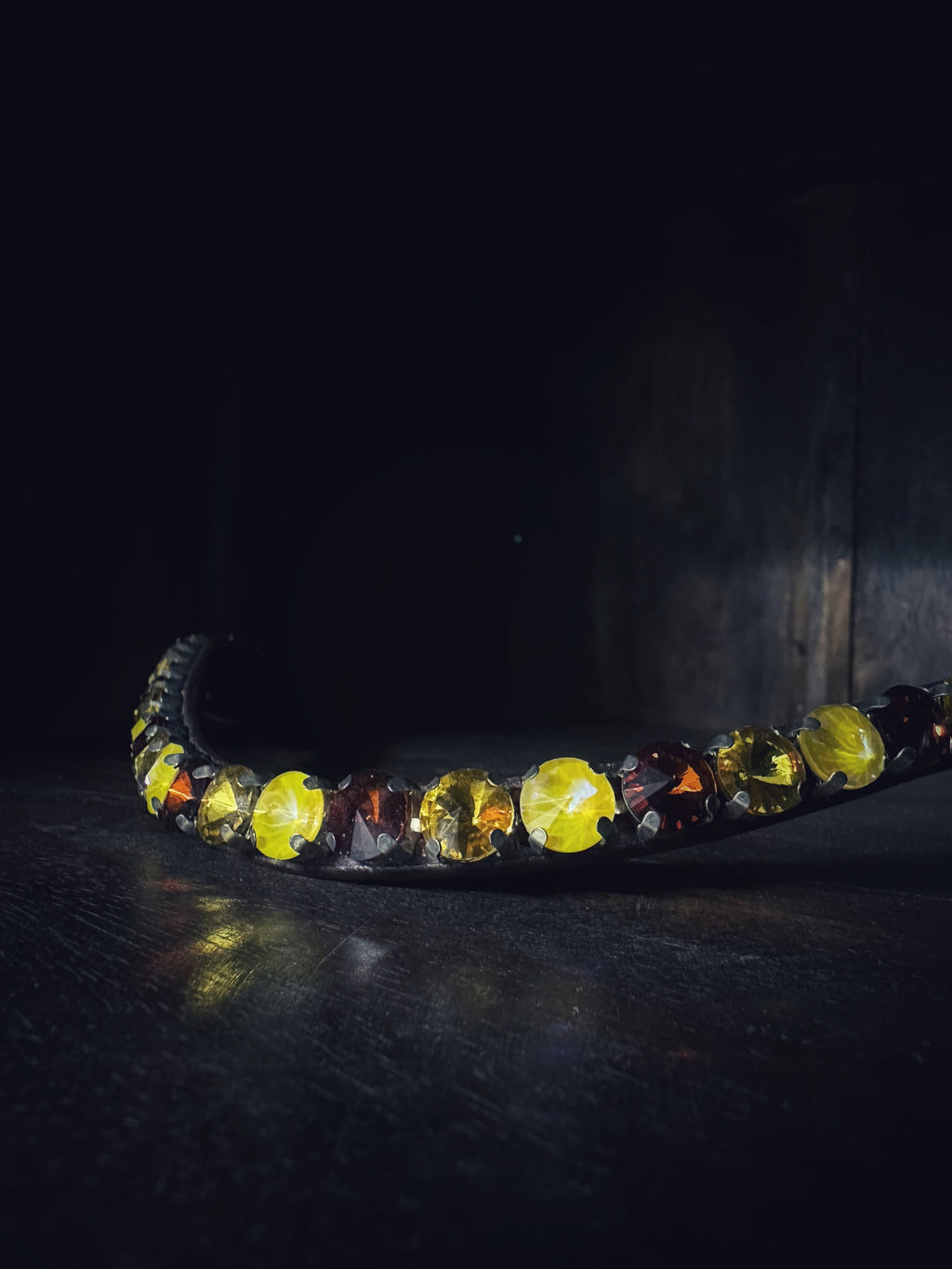 Brown leather cob size pyramids browband with amber and dark gemstones on dark background